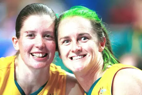 Two Australian wheelchair basketballers, Alison Mosely and Liesl Tesch, lean cheek to cheek and grin at the camera at the 2000 Sydney Paralympic Games.